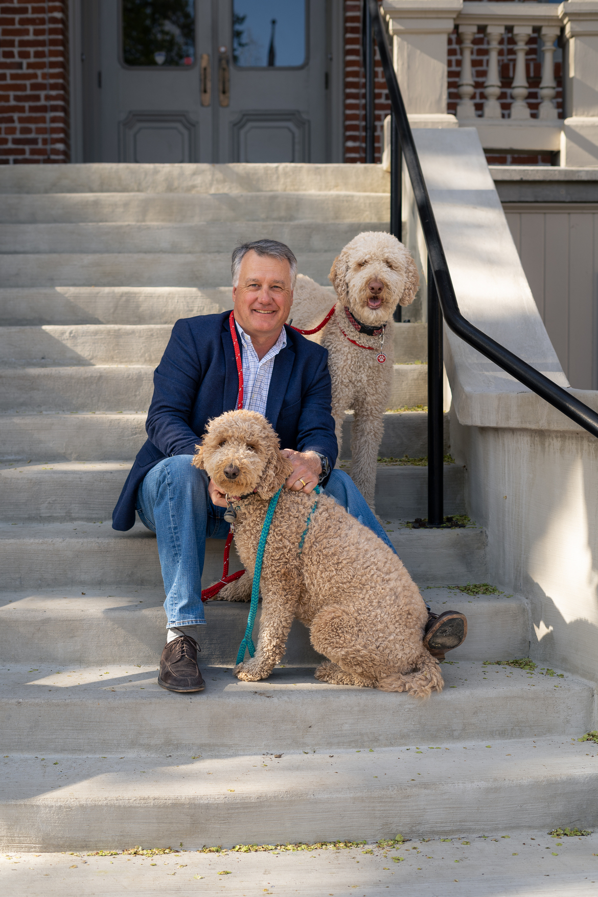 Ellis Ferguson with his dogs Milo and Molly sitting on the steps of Morrill Hall at the University of Nevada, Reno